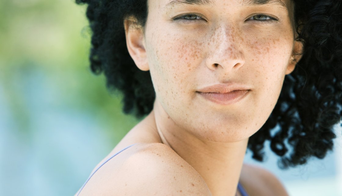 Woman squinting outside from the sun